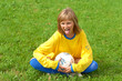 wilful sport girl is siting on the grass with soccer ball wilful sport girl is siting on the grass with soccer ball