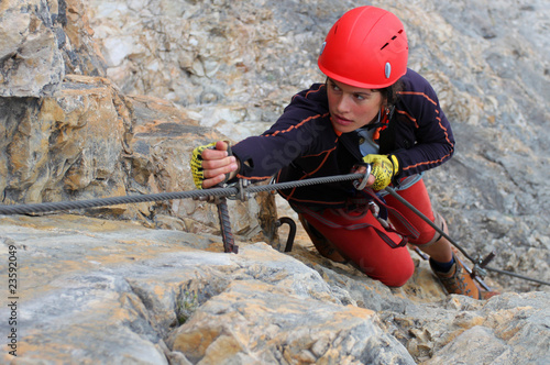 Photo: Young female climber with red helmet Young female climber with red helmet