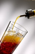 Pour orange liquid into a shaker Pour orange liquid into a shaker