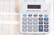 Calculator on top of newspaper with $ figurer amounts