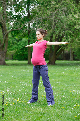 Photo: Beautiful pregnant woman exercising in the park Beautiful pregnant woman exercising in the park