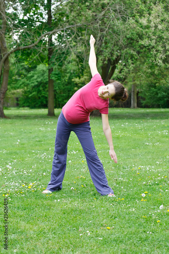 Photo: Beautiful pregnant woman exercising in the park Beautiful pregnant woman exercising in the park