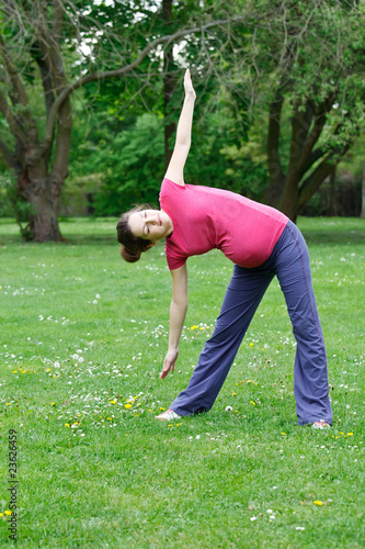 Photo: Beautiful pregnant woman exercising in the park Beautiful pregnant woman exercising in the park