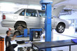 Auto mechanic changing tire under the car. Auto mechanic changing tire under the car.