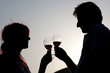 Silhouette of couple clinking glasses of wine
