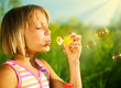 Little girl blowing soap bubbles
