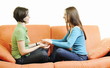 girls playing hand games on orange sofa