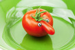 tomato with a nose on a green plate tomato with a nose on a green plate