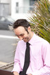 Happy smartly dressed businessman looking dow at laptop