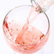 Pink wine being poured into a wine glass Pink wine being poured into a wine glass