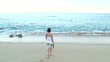 Woman Walking on Sandy Beach