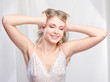 Pretty blond woman waking up and stretching arms