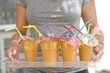 Woman holding a tray with cups