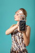 Beautiful fashion girl on the turquoise background with camera Beautiful fashion girl on the turquoise background with camera