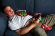England football supporter slob on sofa playing games