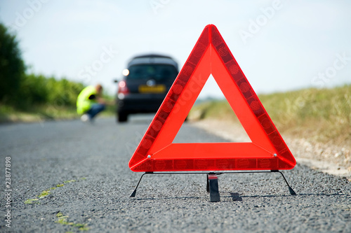 Photo: Red warning triangle with a broken down car Red warning triangle with a broken down car