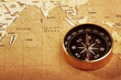 An old brass compass on a Treasure map background An old brass compass on a Treasure map background