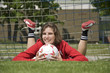 Photo: Junges Mädchen mit Fussball vor dem Tor liegend Junges Mädchen mit Fussball vor dem Tor liegend