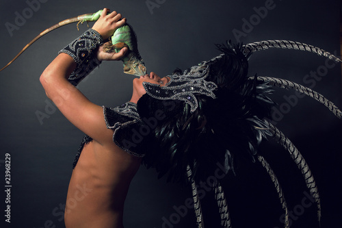 Photo: Young pagan priest in ritual suit with green iguana in his hands Young pagan priest in ritual suit with green iguana in his hands