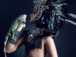 Young pagan priest in ritual suit with green iguana in his hands