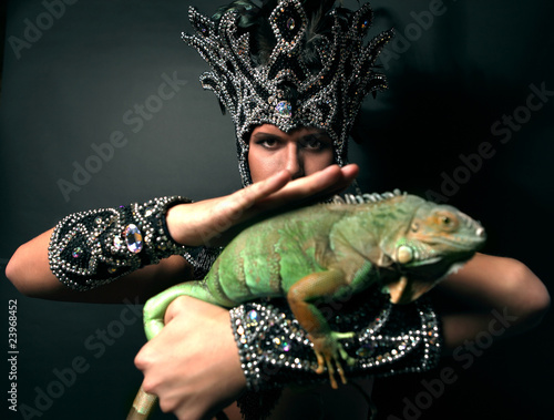 Photo: Young pagan priest in ritual suit with green iguana in his hands Young pagan priest in ritual suit with green iguana in his hands