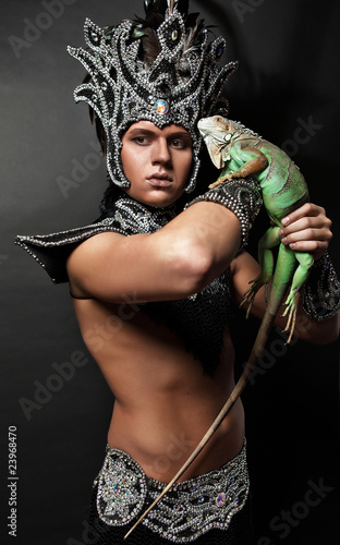 Photo: Young pagan priest in ritual suit with green iguana in his hands Young pagan priest in ritual suit with green iguana in his hands