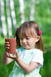 Little girl portrait with glass plum or cherry juice outdoor