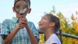 boy and little girl plays with magnifying glass