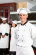 handsome chef with colleagues in kitchen
