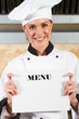 chef holding a white board or menu in kitchen