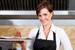 happy waitress holding dessert in kitchen