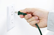Photo: Hand inserting plug into outlet Hand inserting plug into outlet