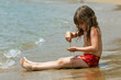 The little girl is sitting on a beach