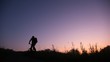 bicyclist rides uphill against sunset sky