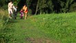 parents helps a kids riding bicycles in park