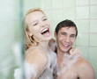 Couple in bathtub covered with soap suds