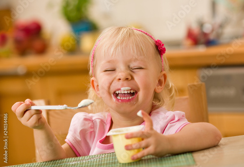 Photo: little girl eating yoghurt little girl eating yoghurt