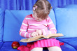 girl reading book with apple at sofa