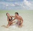 Couple splashing in ocean