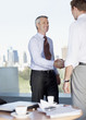 Businessmen shaking hands in cafe