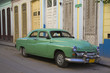 1950s car parked on dilapidated street