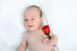 Baby zwinkert mit roter rose