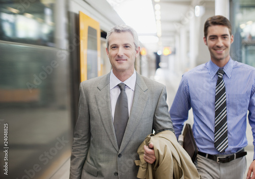 Foto: Businessmen walking on train platform Businessmen walking on train platform