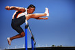 Runner jumping hurdles on track