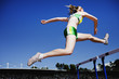Runner jumping hurdles on track
