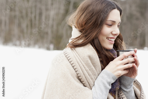 Photo: Woman wrapped in blanket drinking coffee Woman wrapped in blanket drinking coffee