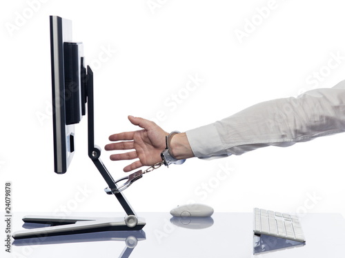 Photo: Hand chained to computer with handcuffs Hand chained to computer with handcuffs