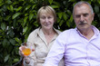 Photo: Handsome Senior Couple relaxing and drinking in the Garden Handsome Senior Couple relaxing and drinking in the Garden