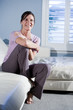 Happy woman sitting on couch smiling