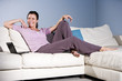 Happy woman relaxing on couch smiling with laptop